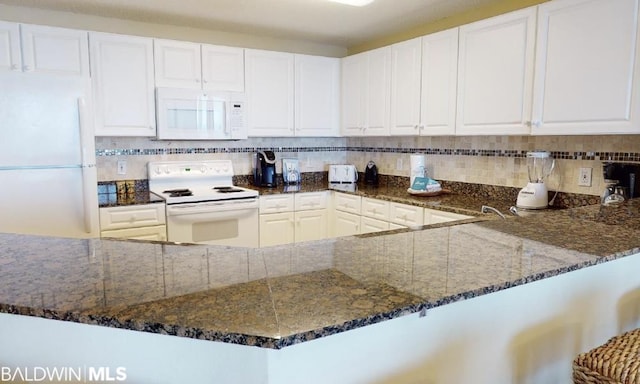 kitchen featuring white appliances, white cabinets, dark stone countertops, and tasteful backsplash