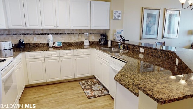 kitchen with light hardwood / wood-style flooring, sink, dark stone counters, and white cabinets