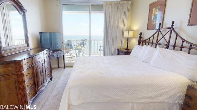 bedroom featuring a water view, access to outside, and light wood-type flooring