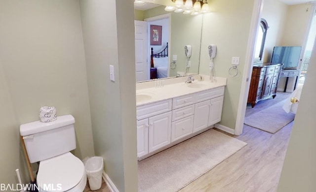 bathroom with toilet, hardwood / wood-style floors, double sink, and oversized vanity