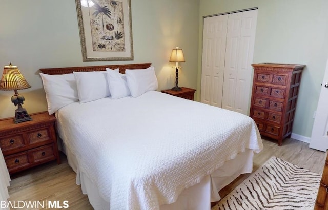 bedroom with a closet and light hardwood / wood-style floors