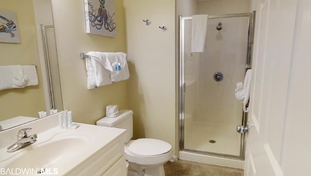 bathroom featuring toilet, large vanity, and an enclosed shower