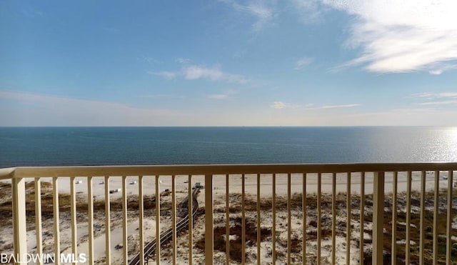 balcony featuring a beach view and a water view