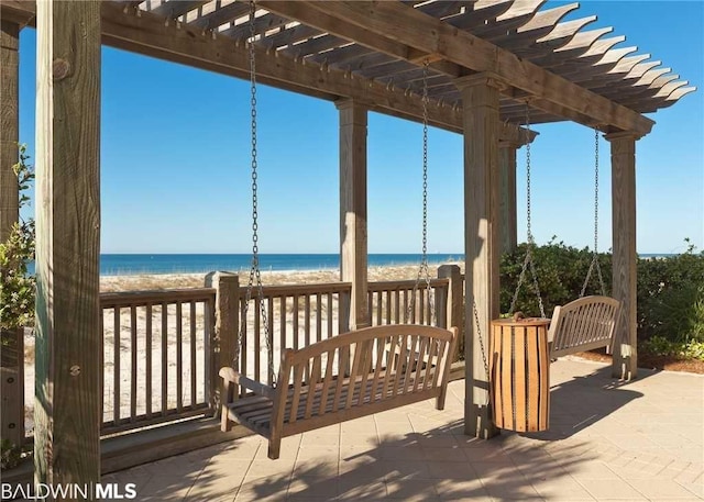 wooden terrace featuring a view of the beach, a pergola, and a water view