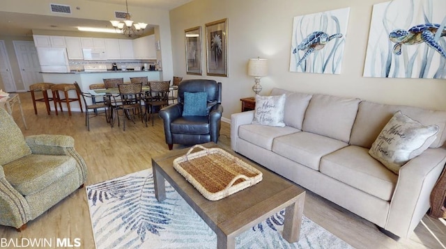 living room with light hardwood / wood-style flooring and an inviting chandelier