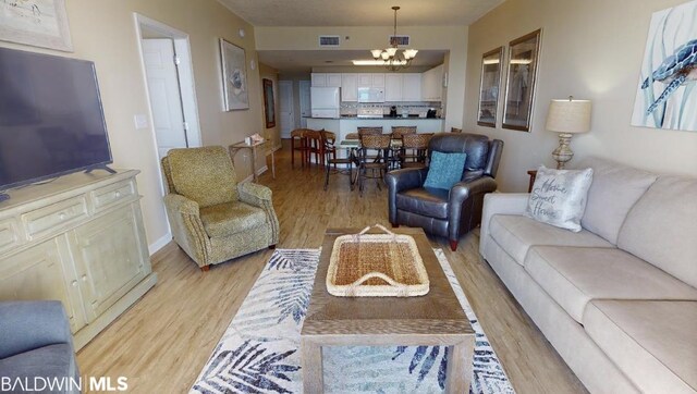 living room featuring a notable chandelier and light hardwood / wood-style flooring