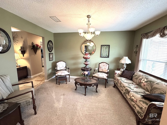 living area with a chandelier, carpet floors, visible vents, and baseboards