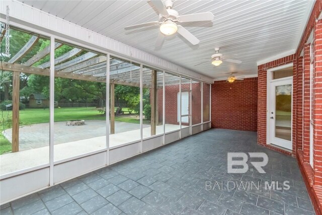 unfurnished sunroom with ceiling fan