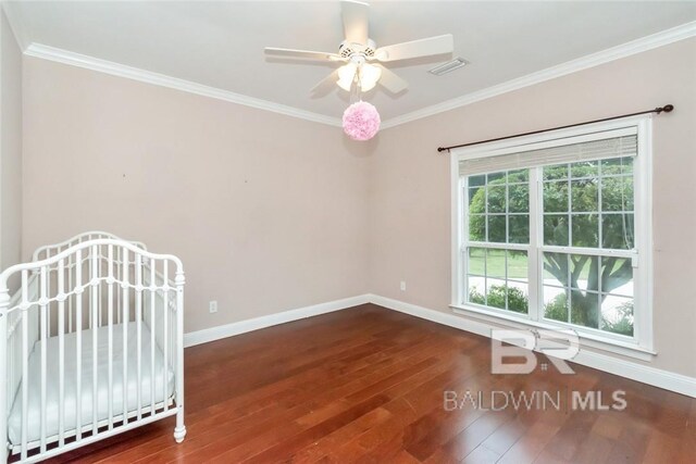 unfurnished bedroom featuring ceiling fan, dark hardwood / wood-style flooring, and crown molding