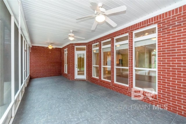 unfurnished sunroom featuring ceiling fan