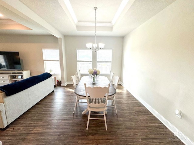 dining space with an inviting chandelier, dark hardwood / wood-style floors, and a tray ceiling