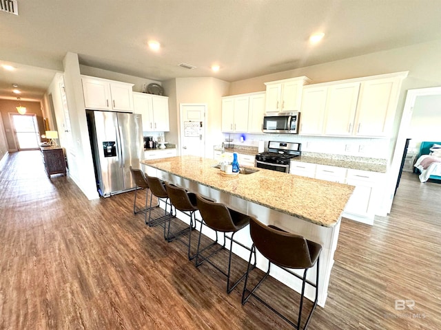 kitchen featuring white cabinets, a kitchen bar, and stainless steel appliances