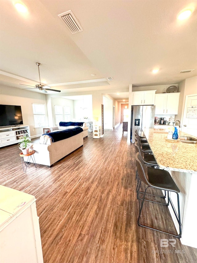 living room featuring sink, dark wood-type flooring, and ceiling fan