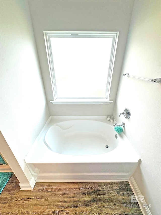 bathroom featuring hardwood / wood-style flooring and a bath