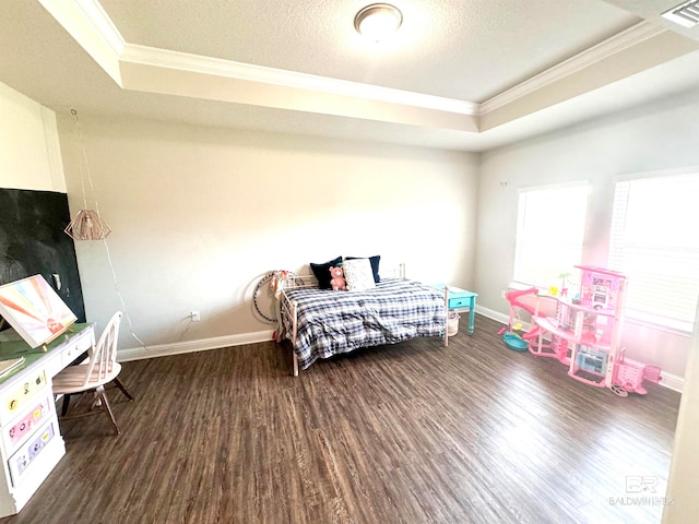 bedroom with crown molding, a tray ceiling, and dark wood-type flooring