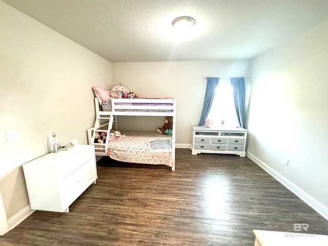 bedroom featuring a textured ceiling and dark hardwood / wood-style flooring