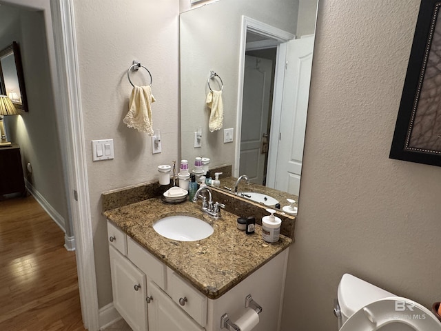 1052 Orlando Dr, Foley, AL 36535 - half bathroom featuring wood finished floors, vanity, toilet, and baseboards