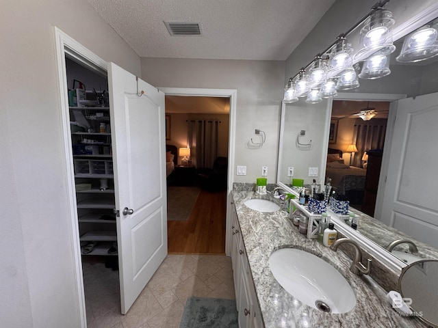 1052 Orlando Dr, Foley, AL 36535 - bathroom featuring ensuite bath, tile patterned flooring, double vanity, ceiling fan, and a textured ceiling