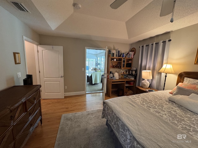 1052 Orlando Dr, Foley, AL 36535 - bedroom with wood finished floors, a raised ceiling, a textured ceiling, an office area, and a ceiling fan