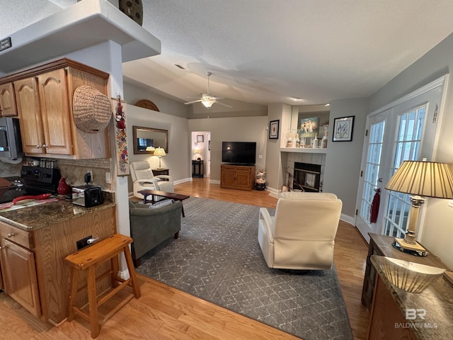 1052 Orlando Dr, Foley, AL 36535 - living area with a fireplace, wood finished floors, a ceiling fan, vaulted ceiling, and baseboards