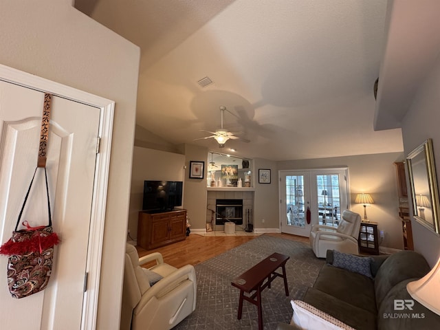1052 Orlando Dr, Foley, AL 36535 - living room with a ceiling fan, vaulted ceiling, a tile fireplace, baseboards, and wood finished floors