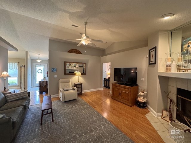 1052 Orlando Dr, Foley, AL 36535 - living room featuring wood finished floors, ceiling fan, baseboards, lofted ceiling, and a fireplace