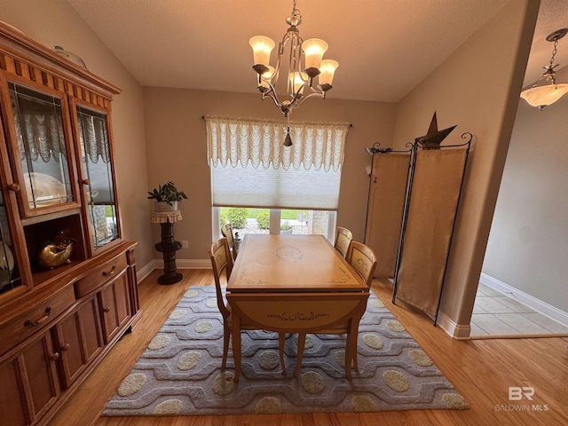 1052 Orlando Dr, Foley, AL 36535 - dining space with a chandelier, light wood-type flooring, baseboards, and a textured ceiling