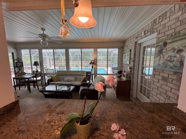 1052 Orlando Dr, Foley, AL 36535 - carpeted living area with brick wall and ceiling fan
