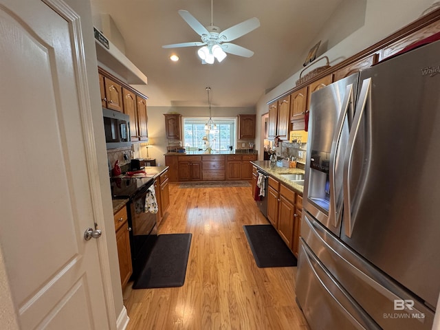 1052 Orlando Dr, Foley, AL 36535 - kitchen featuring stainless steel appliances, brown cabinets, light wood-style floors, a ceiling fan, and decorative light fixtures