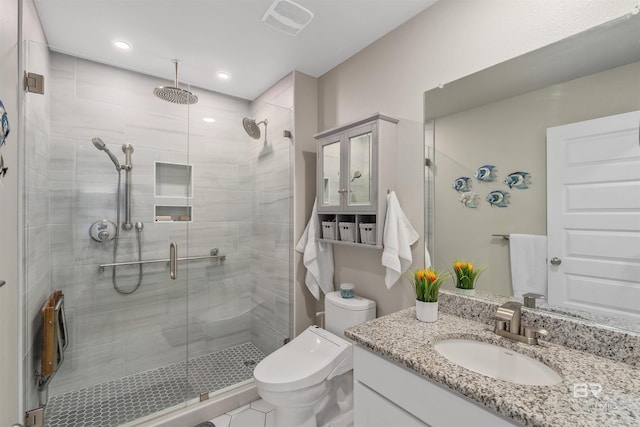 bathroom featuring vanity, a shower with shower door, and toilet