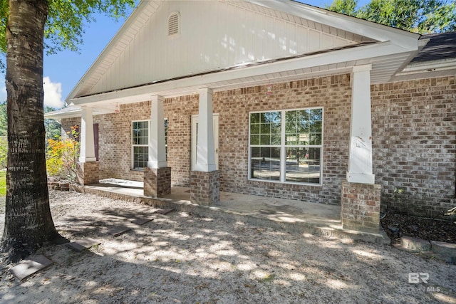 back of property featuring covered porch