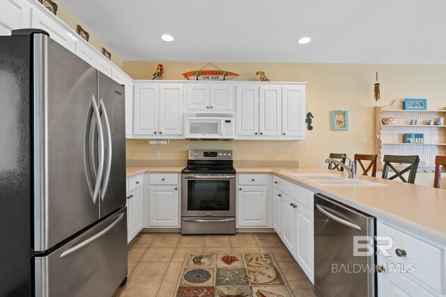 6065 Sawgrass Dr, Gulf Shores, AL 36542 - kitchen with stainless steel appliances, white cabinets, and light countertops