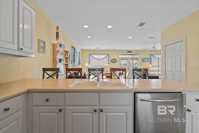 6065 Sawgrass Dr, Gulf Shores, AL 36542 - kitchen featuring a peninsula, a sink, light countertops, white cabinetry, and stainless steel dishwasher