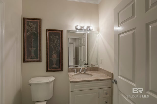 bathroom featuring vanity, toilet, and crown molding