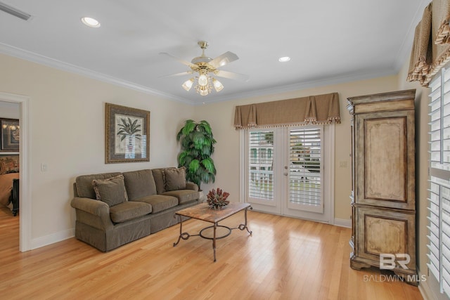 living room featuring ceiling fan, light wood-type flooring, and ornamental molding