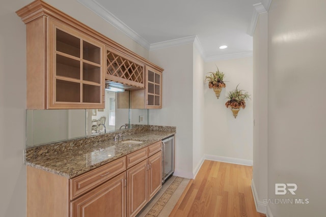 kitchen featuring stone countertops, sink, crown molding, and light hardwood / wood-style flooring