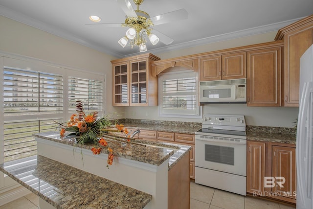 kitchen featuring light tile patterned floors, white appliances, and stone countertops