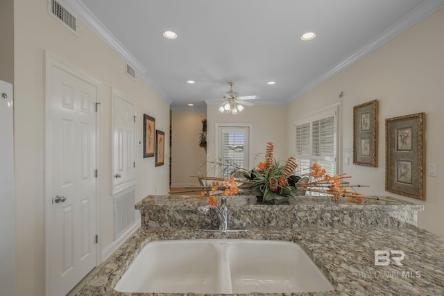 kitchen with ornamental molding, kitchen peninsula, ceiling fan, and sink