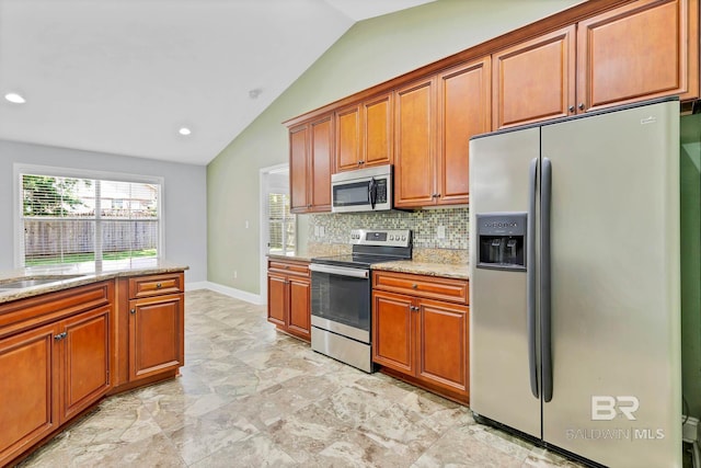 28165 Turkey Branch Dr, Daphne, AL 36526 - kitchen with appliances with stainless steel finishes, vaulted ceiling, tasteful backsplash, light stone countertops, and brown cabinetry