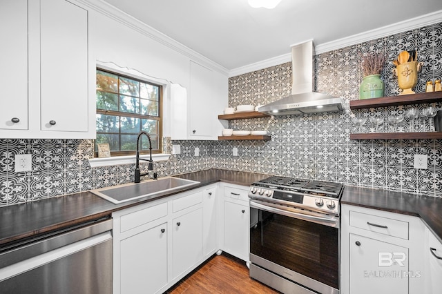 kitchen with sink, crown molding, wall chimney range hood, stainless steel appliances, and white cabinets