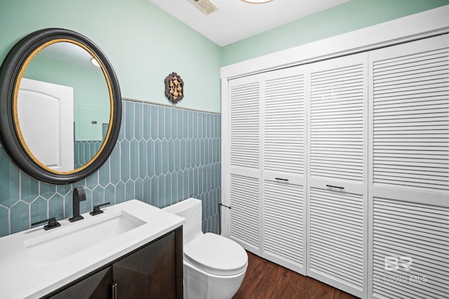 bathroom with vanity, wood-type flooring, tile walls, and toilet