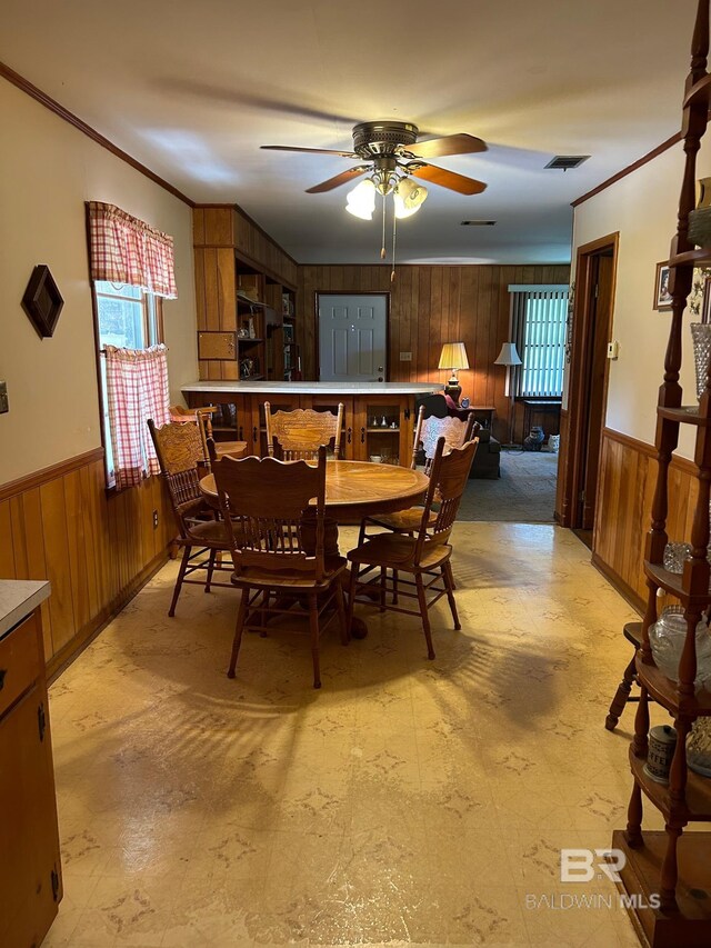 living room with carpet flooring, ceiling fan, and wood walls