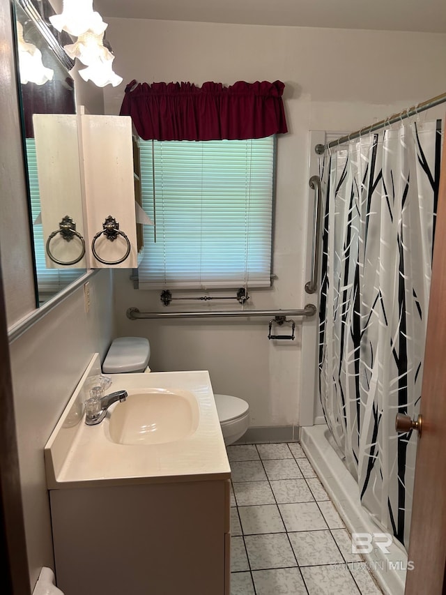 bathroom with tile patterned floors, vanity, toilet, and walk in shower