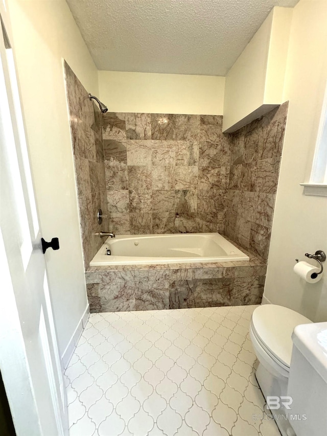 bathroom with tiled shower / bath combo, a textured ceiling, toilet, and tile floors