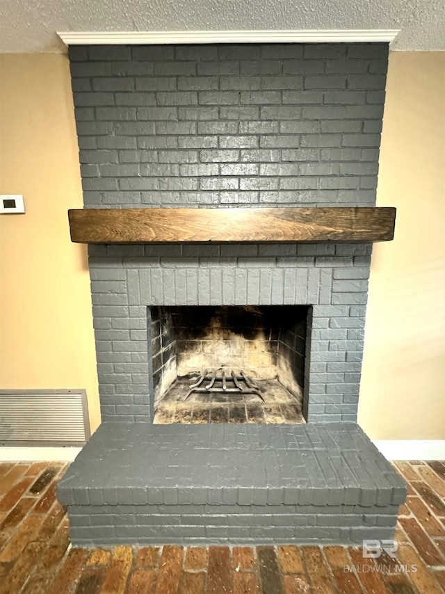 details with a textured ceiling and a brick fireplace