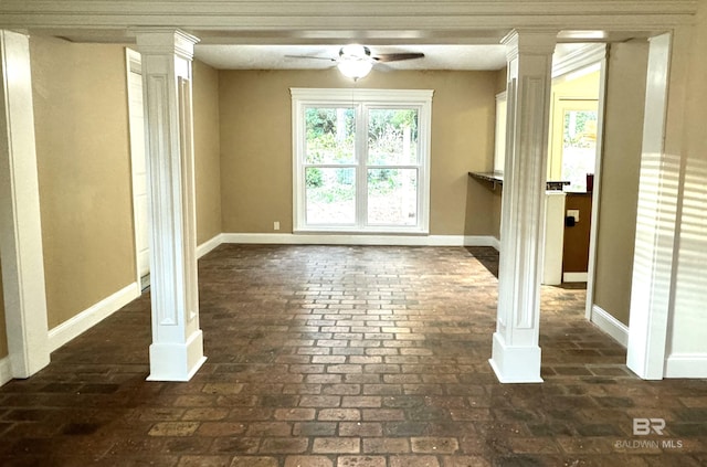 spare room with decorative columns and ceiling fan