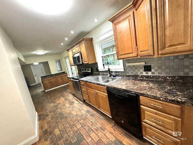 kitchen featuring tasteful backsplash, dark stone counters, appliances with stainless steel finishes, and sink