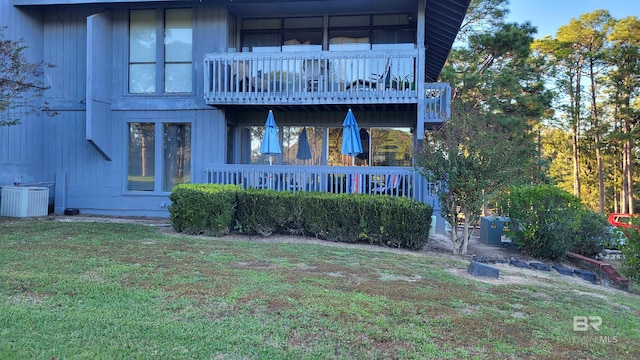 back of house featuring central air condition unit and a lawn