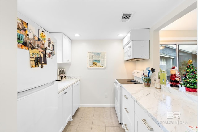 kitchen with white cabinetry, light tile patterned floors, light stone countertops, and white appliances