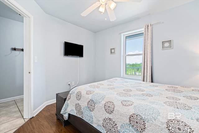 bedroom with baseboards, wood finished floors, and a ceiling fan